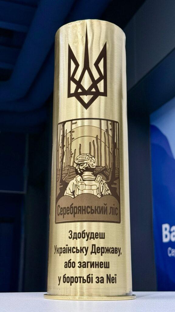 Тризуб, ілюстрація бійця у лісі, напис «Серебрянський ліс» і рядки із клятви: «Здобудеш Українську Державу, або загинеш у боротьбі за Неї» — потужне патріотичне гравіювання.
