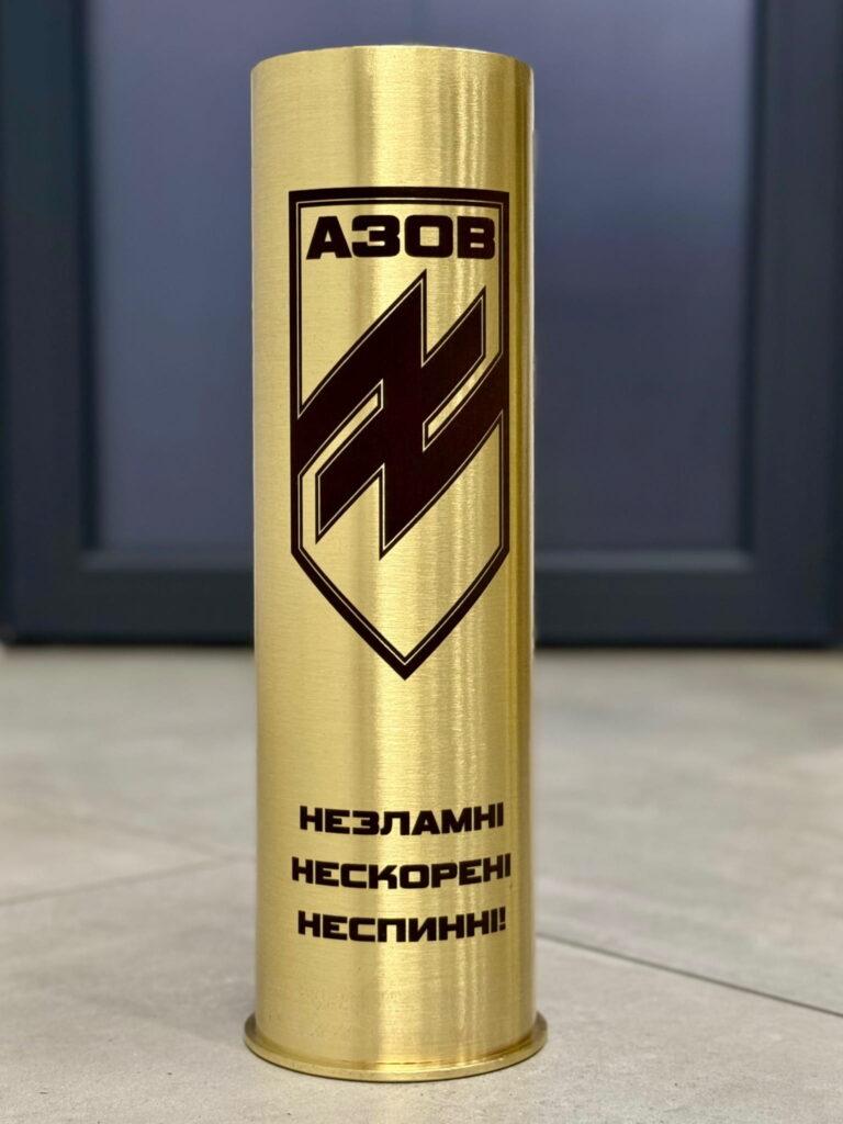 Гільза на тлі підлоги — реальні умови, реальна якість. Гравіювання залишається чітким і читаємим під будь-яким кутом освітлення.