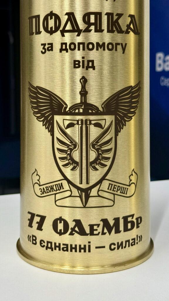 гравіювання шеврону 77 ОАеМБр на латунній артилерійській гільзі, напис «В єднанні — сила!»