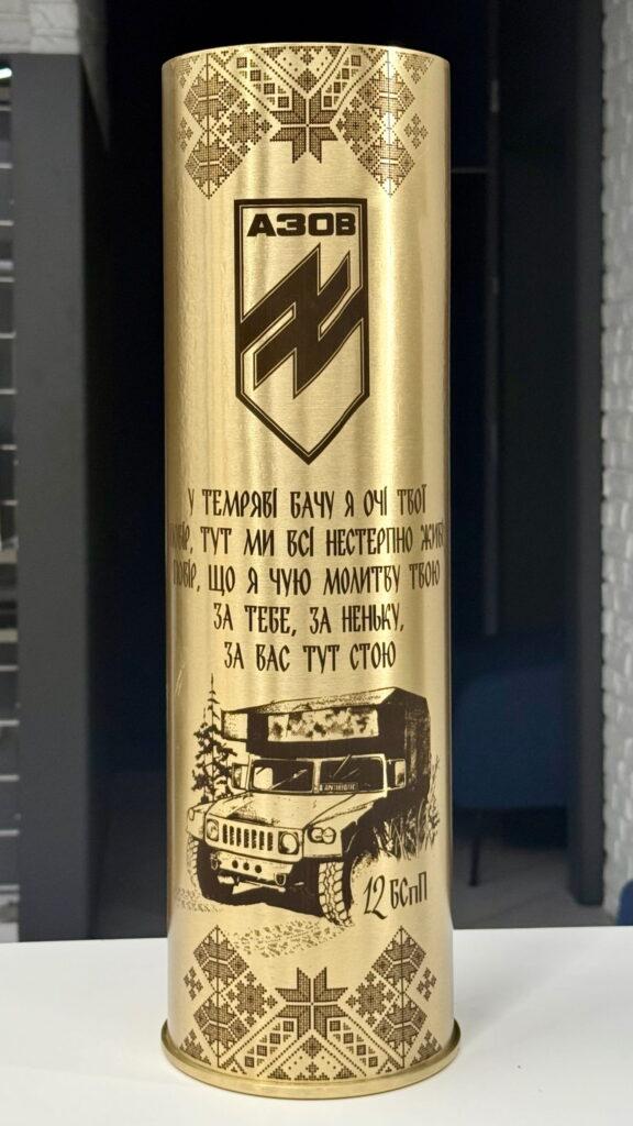 Орнамент вишиванки обрамлює горло гільзи, шеврон АЗОВ, рядки з пісні, деталізована ілюстрація бойового автомобіля Humvee «Antibiotic» та «12 БСпП». Поєднання народного і бойового — в одному виробі.