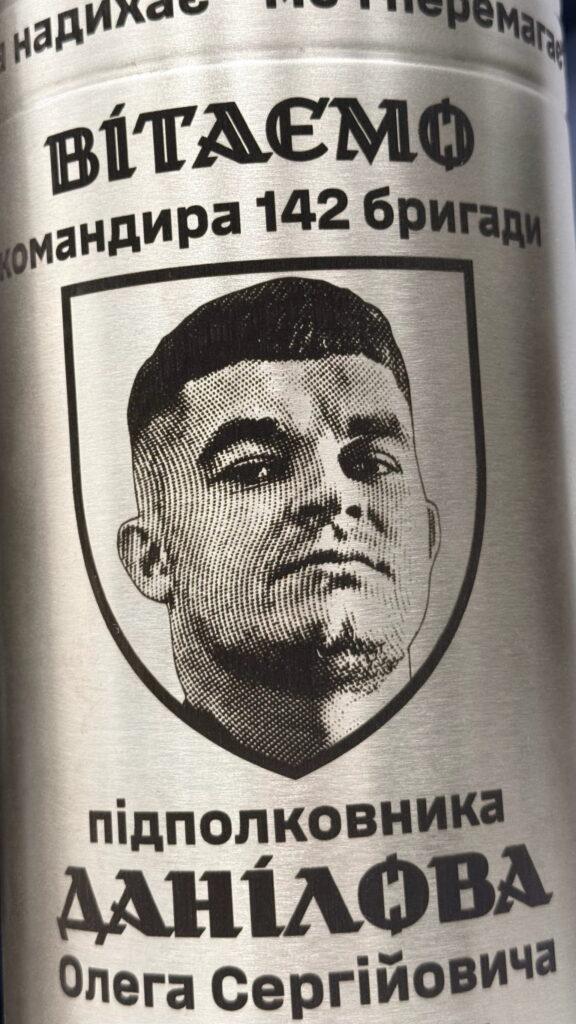Крупний план лазерного гравіювання портрету командира бригади підполковника в шевроні — деталі обличчя у техніці пунктирної гравюри на латунній поверхні Детальний знімок, що показує якість опрацювання портрету. Кожна деталь обличчя чітко читається. Саме так виглядає лазерне гравіювання, зроблене майстерно.